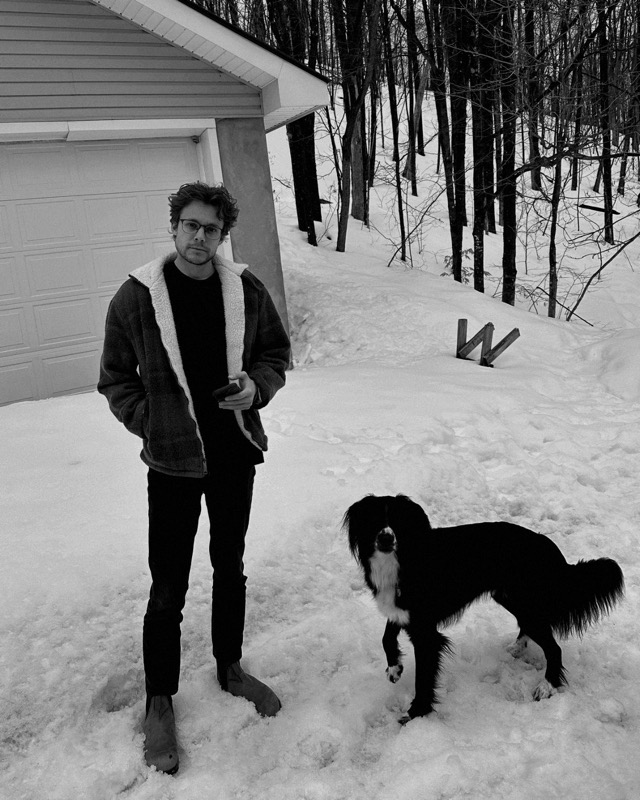 Nick Magalhaes standing in the snow with his dog